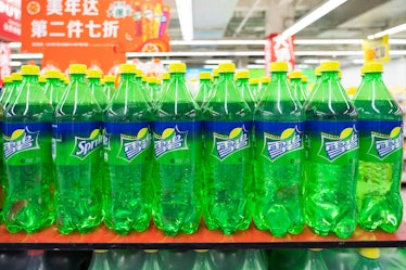 Plastic green, blue, and yellow Sprite bottles on a shelf.