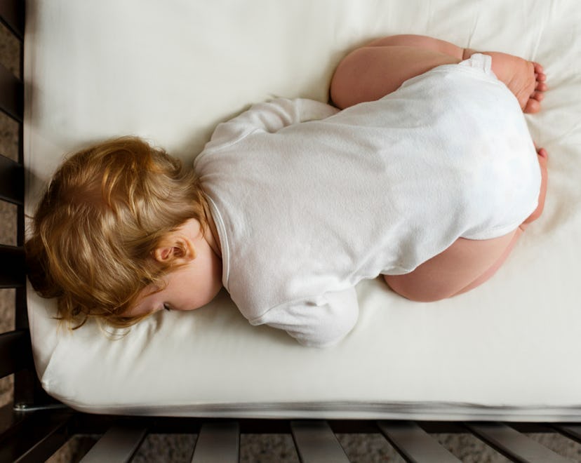 Baby sleeping face down with butt in the air in a crib, in a story answering the question, why do ba...