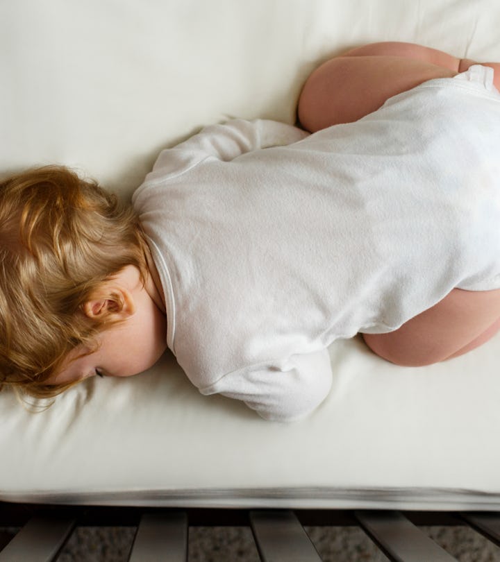 Baby sleeping face down with butt in the air in a crib, in a story answering the question, why do ba...