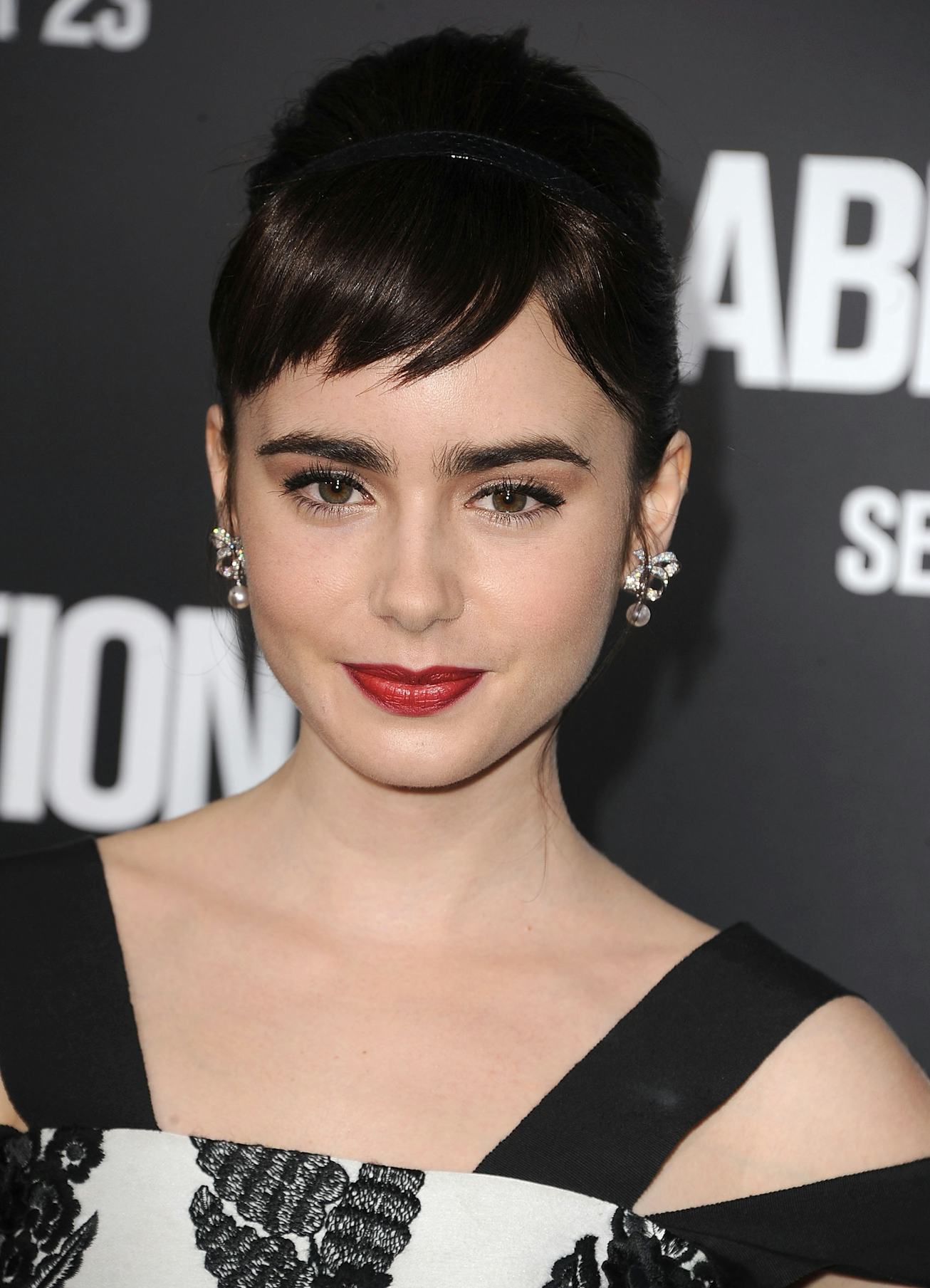 Lily Collins attends the 2011 premiere of Abduction, wearing red lipstick with an updo