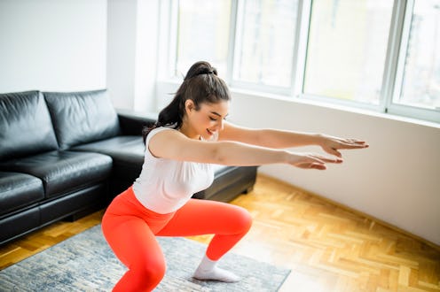 woman doing a squat, a move that's typical for a HIIT workout for beginners