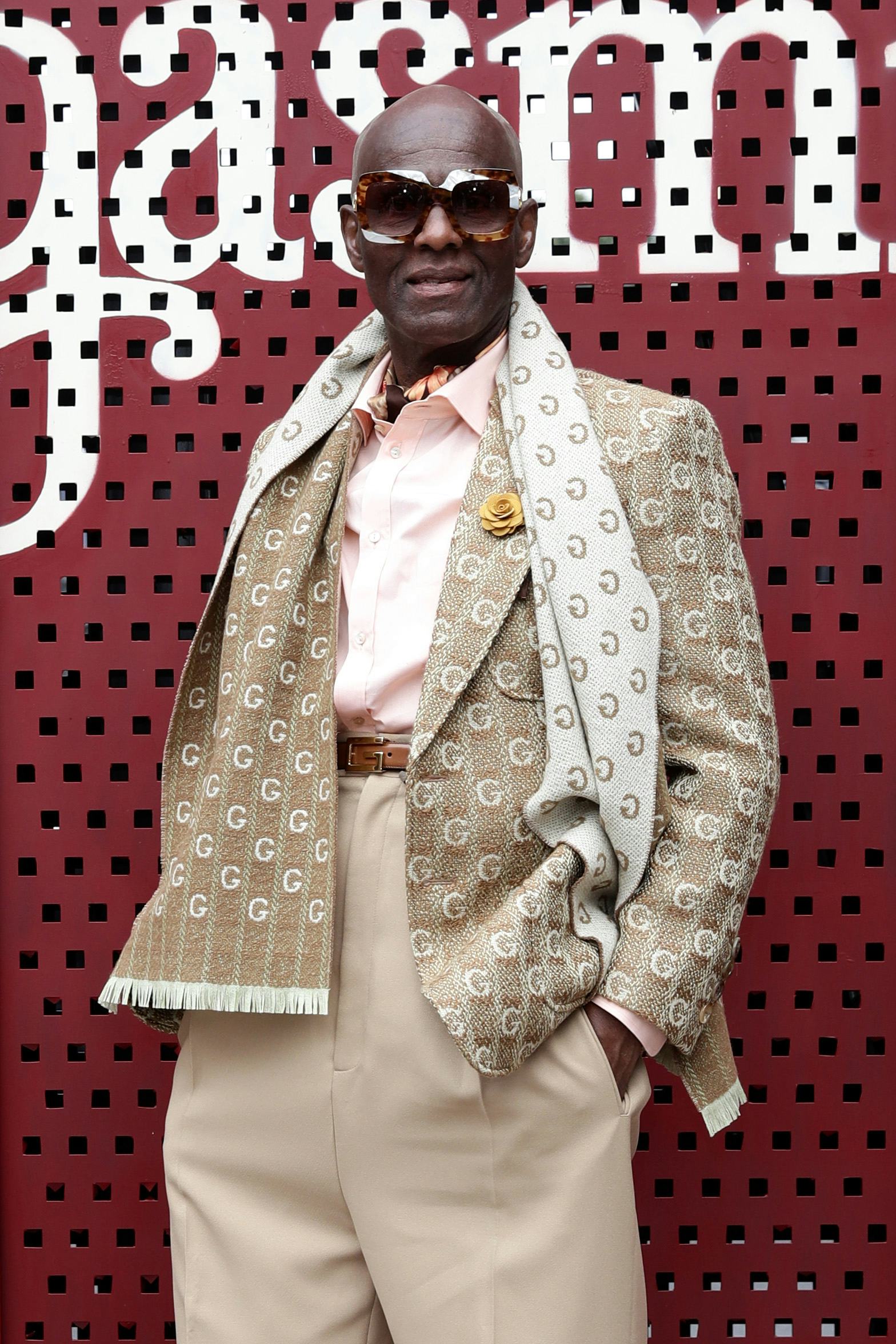 Dapper Dan at an event in a beige suit and a scarf