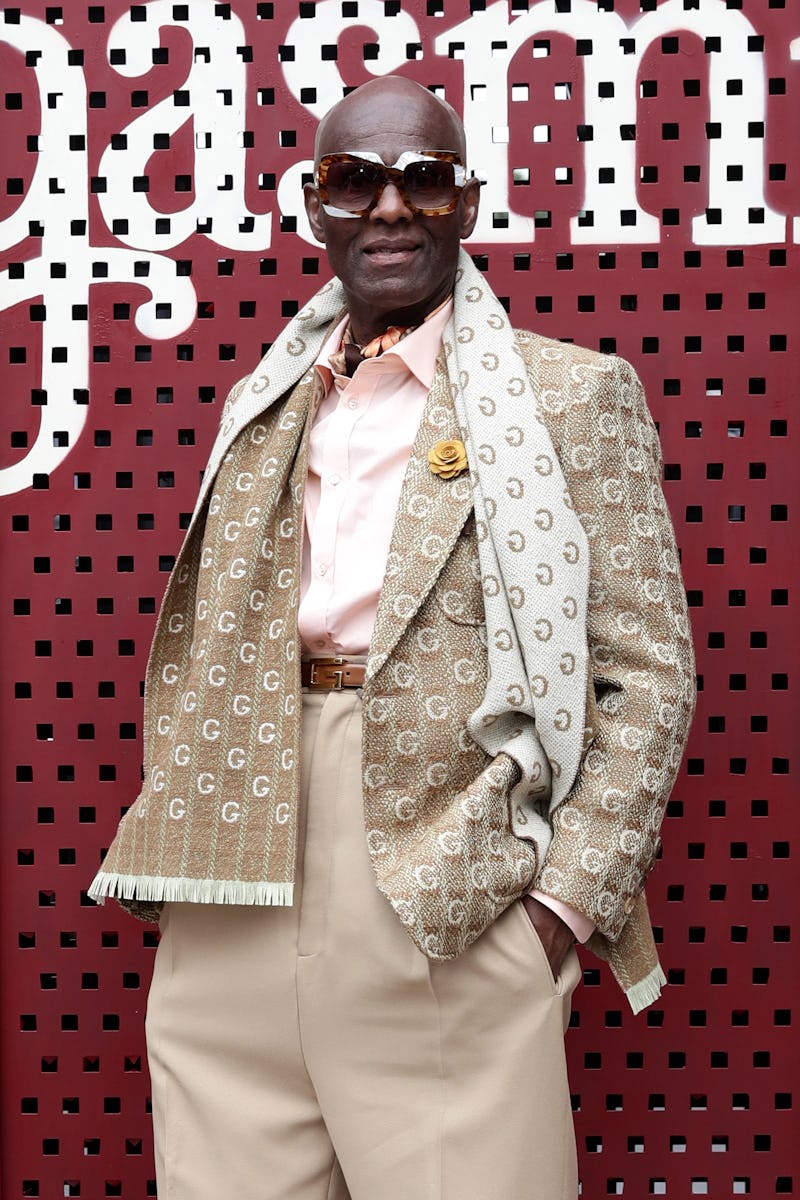 Dapper Dan at an event in a beige suit and a scarf