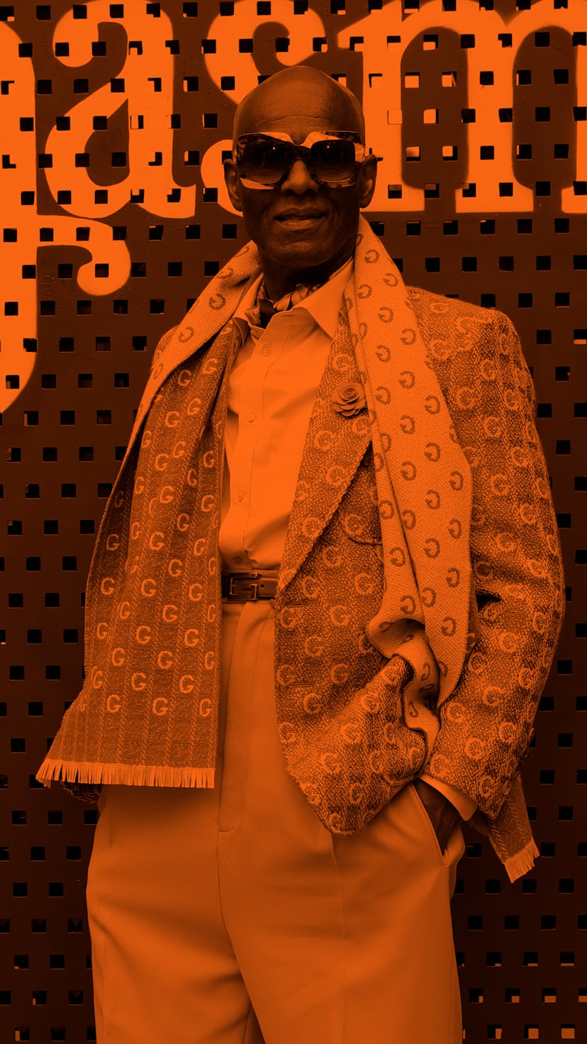 Dapper Dan at an event in a beige suit and a scarf