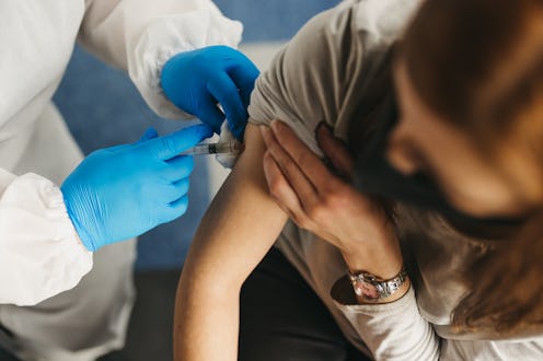 A young person receives a COVID vaccine. Early recipients of COVID vaccines report feeling a mix of ...