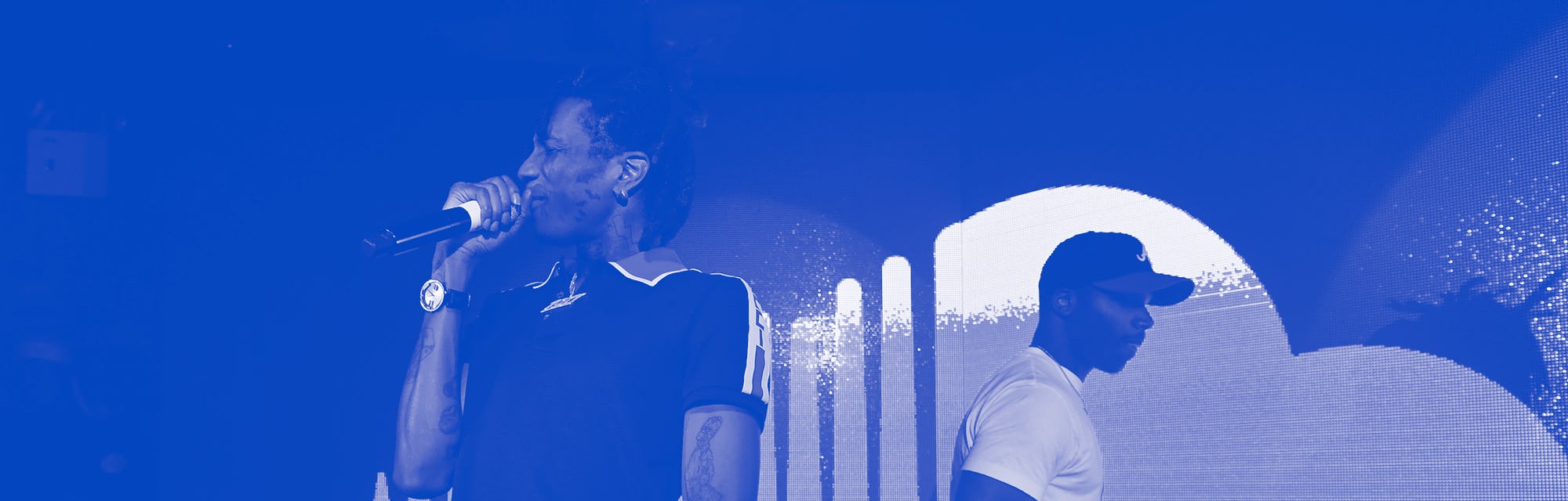 Two musicians performing on a stage, in front of a SoundCloud logo.