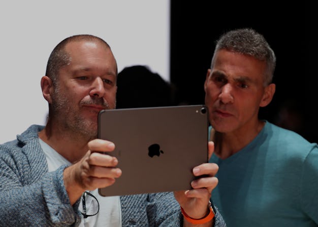 Apple executives Jony Ive and Dan Riccio look into the screen of an iPad. 
