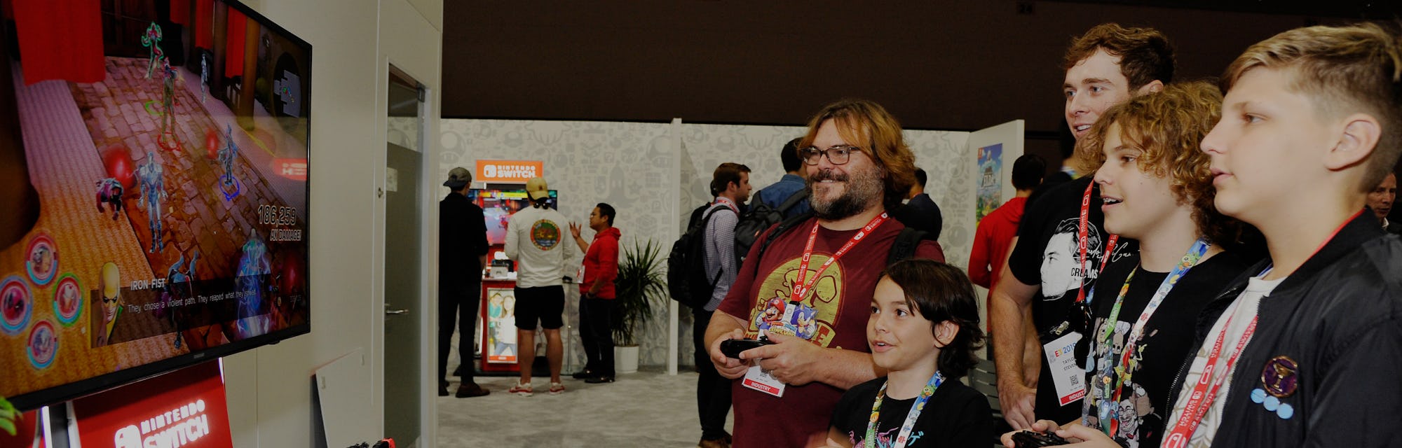 Actor Jack Black playing video games with attendees of the E3 gaming expo.