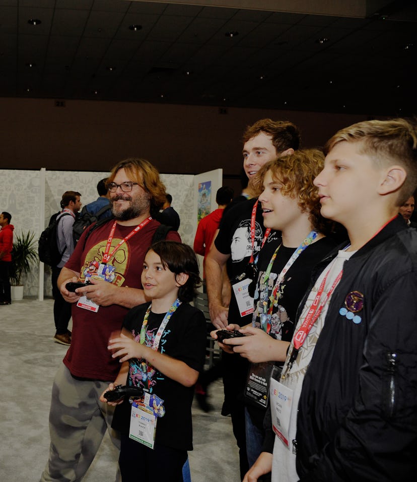 Actor Jack Black playing video games with attendees of the E3 gaming expo.