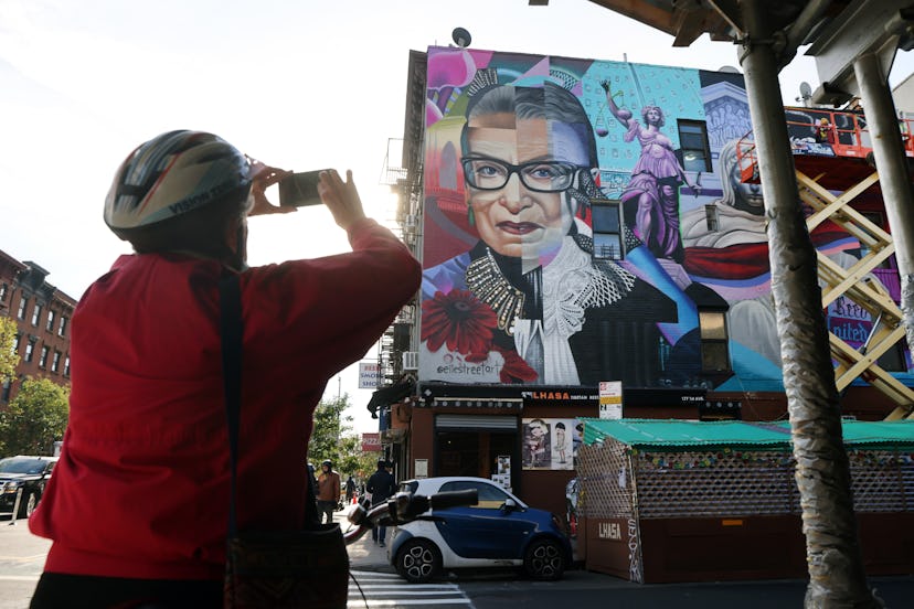 woman taking a picture of ruth bader ginsburg mural