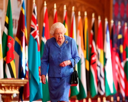 Britain's Queen Elizabeth II walks past Commonwealth flags displayed in St George's Hall at Windsor ...