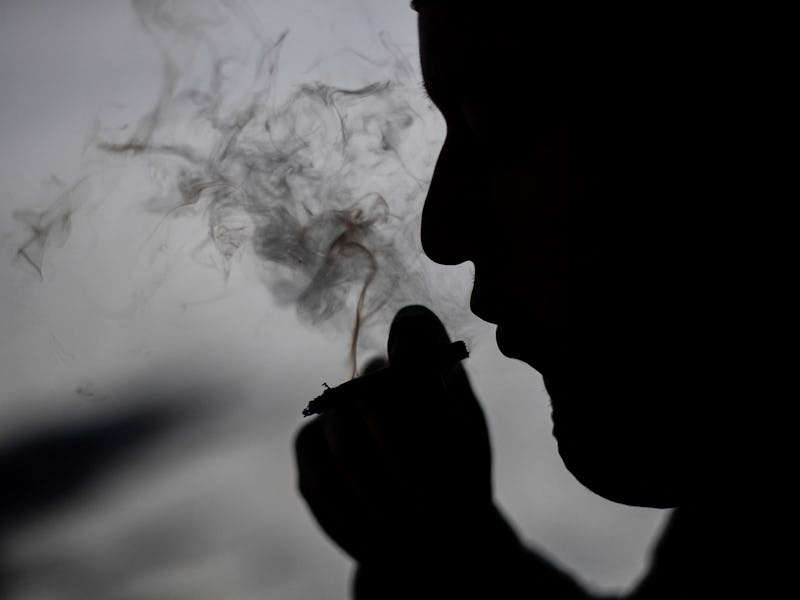 A man smokes a joint, at the esplanade of the Estela de Luz in Mexico City, on March 9, 2021 on the ...