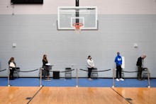 People wait in line to receive a dose of the Moderna Covid-19 vaccine at a clinic for Catholic schoo...