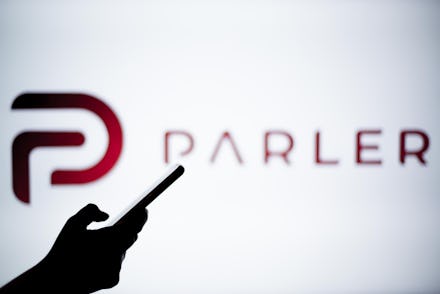 SPAIN - 2021/01/14: In this photo illustration a Parler logo is seen behind a smartphone.
The 'free ...