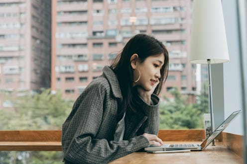 Asian female student using computer in library