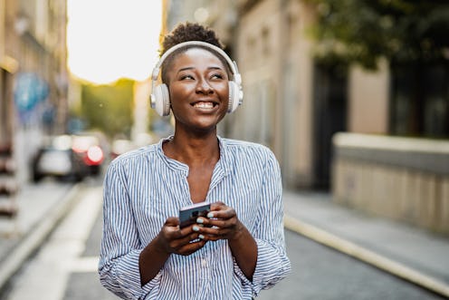 Young African American woman is in the city and using a mobile phone