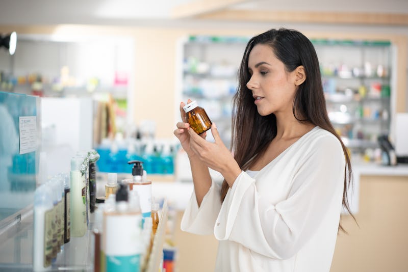 Woman choosing sunscreen lotion at the pharmacy