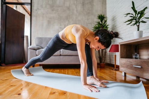 Young attractive woman practicing yoga at home.