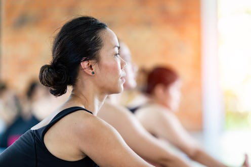 Fitness asian female group doing warm up yoga pose in row at the yoga class, Ubon Ratchathani, Thail...