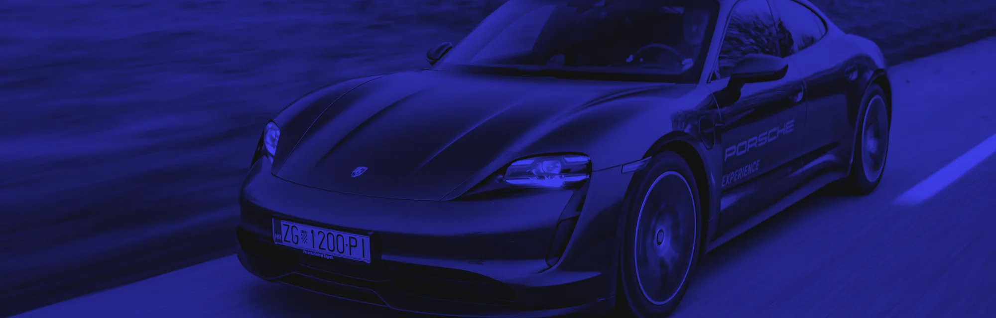 Zagreb, Croatia - December 8, 2020: Man is driving Porsche Taycan fast on the road. Taycan is all electric four door sports coupe made by famous German sports car manufacturer Porsche.