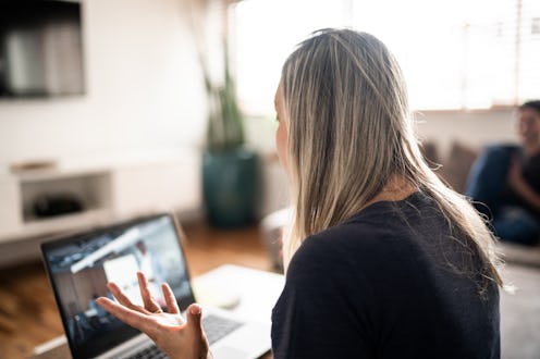 Rear view of a mature woman doing a business video call at home