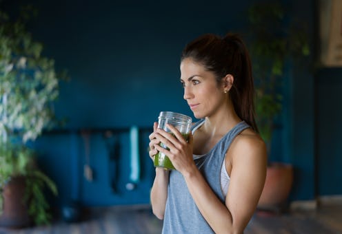 Portrait of an athletic Latin American woman drinking a detox smoothie at the gym - healthy lifestyl...