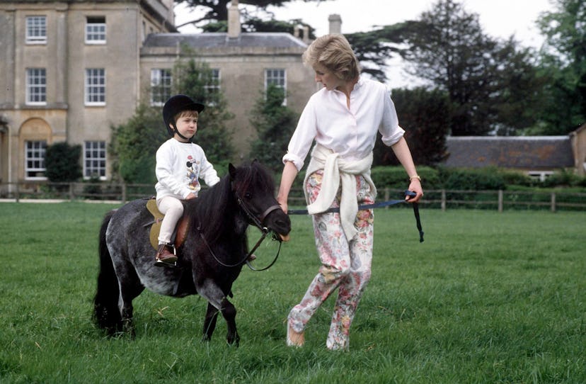 Princess Diana shows Prince William how to ride a pony.