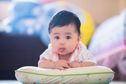 Baby sticking her tongue out, in a story answering the question, why do babies stick their tongue ou...