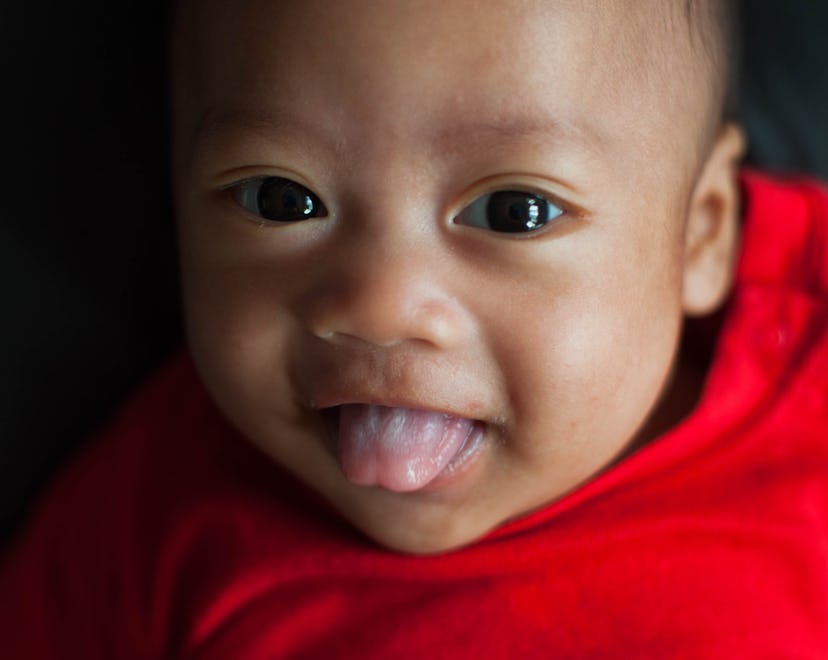 Baby sticking its tongue out, in a story answering the question, why do babies stick their tongue ou...