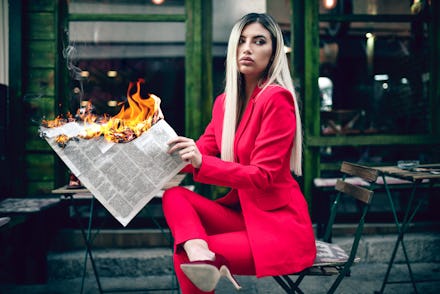 Elegant Female Reading Burning Newspaper