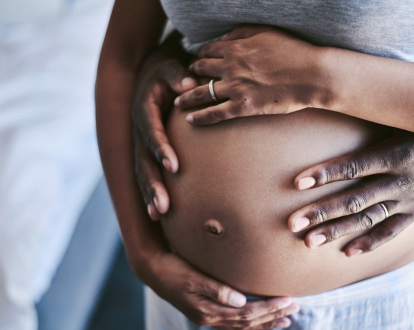 Cropped shot of an unrecognizable man and his wife touching her pregnant belly in a story about sign...
