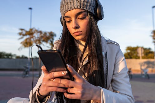 Woman listens to Clubhouse event. The party emoji on Clubhouse signifies people who are new to the a...