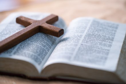 The cross is placed on the Bible.