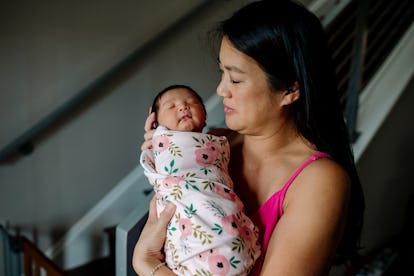 baby swaddled in blanket in mother's arms