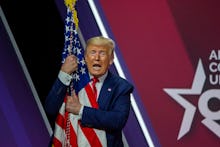 NATIONAL HARBOR, MARYLAND - FEBRUARY 29: President Donald Trump hugs the flag of the United States o...