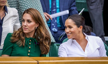 Catherine, Duchess of Cambridge sits with Meghan, Duchess of Sussex in the Royal Box on Centre Court...