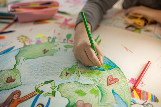 Close up of child's hands while drawing Ecofriendly theme on paper.
