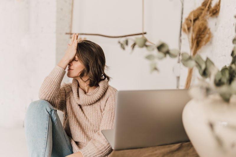 A tired woman in front of a laptop. Steps to take if you're sexually harassed at work.