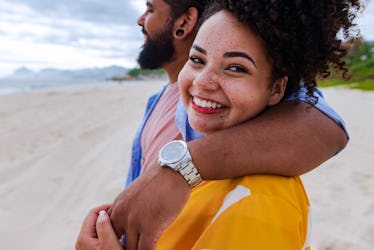 Happy couple in love, walking the beach on sunny day