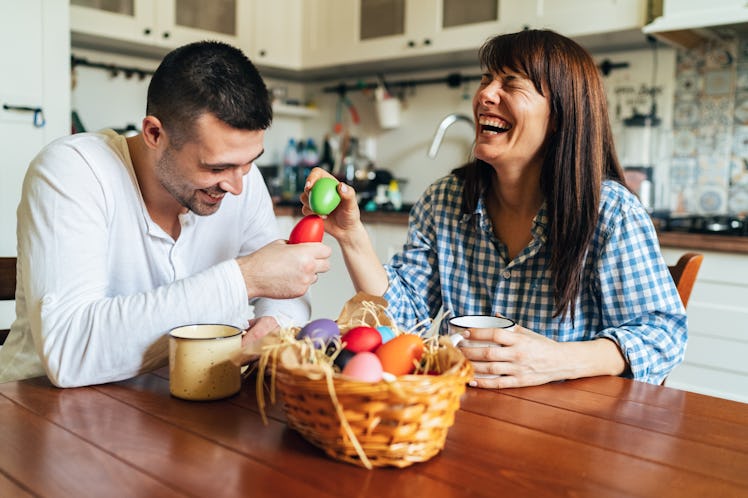 Happy siblings playing with Easter eggs and laughing.