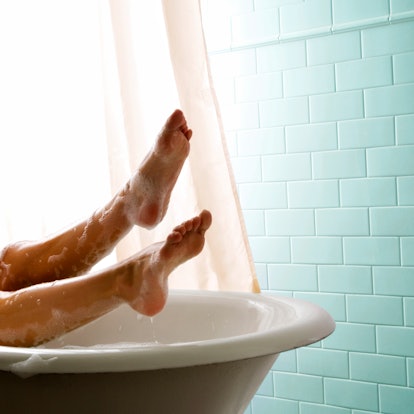 Legs of woman in bubble bath relaxing.