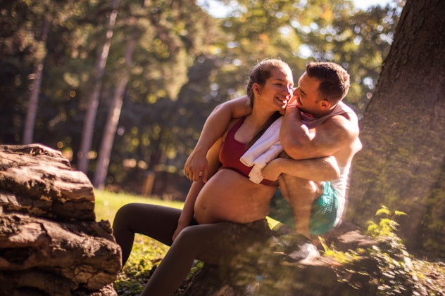 Pregnant woman and her partner kiss on a hike, in a story about leaky breasts during sex.