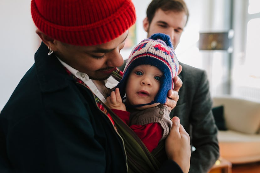 Dad holds baby dressed for winter weather in a story about how to dress baby for cold temperatures.