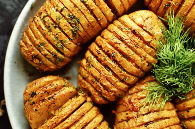 A plate of accordion potatoes sits in a kitchen.