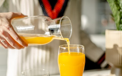 Details of woman preparing fresh orange in her kitchen