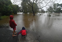 SYDNEY, AUSTRALIA - MARCH 22: Children play in the water at a flooded road in Richmond, north west o...