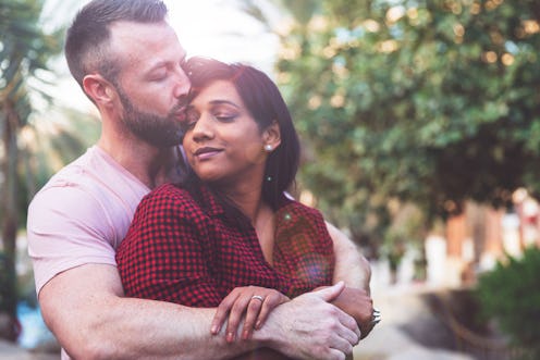 Young couple cuddling outside their resort chalet