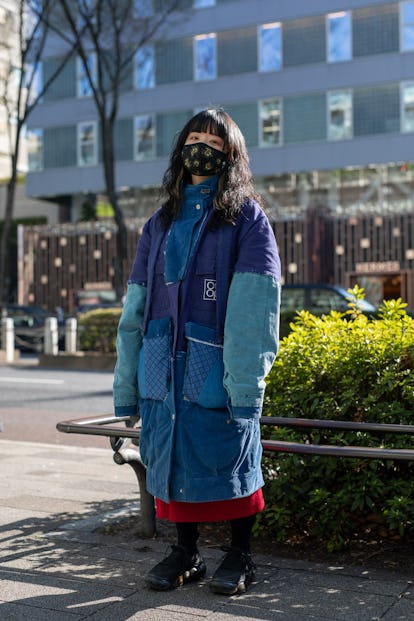 TOKYO, JAPAN - MARCH 15: A guest is seen on the street wearing blue Nisai coat, black sneakers, blac...