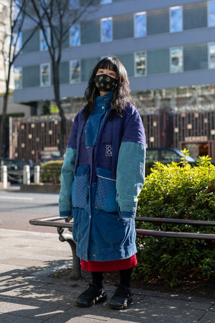 TOKYO, JAPAN - MARCH 15: A guest is seen on the street wearing blue Nisai coat, black sneakers, blac...