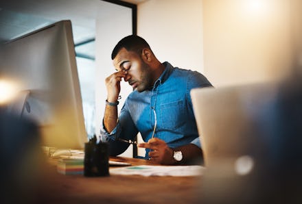 Shot of a young businessman experiencing stress during a late night at work